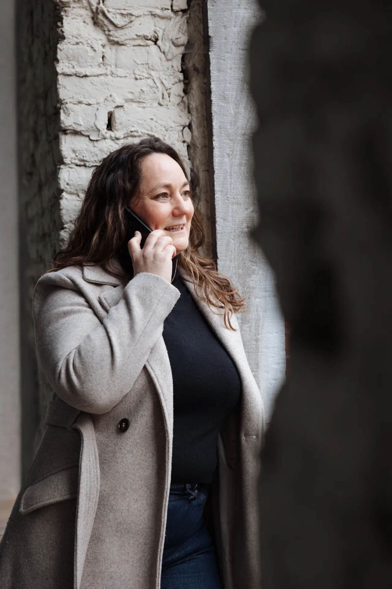 Annelies aan de telefoon in een doorgang, geconcentreerd