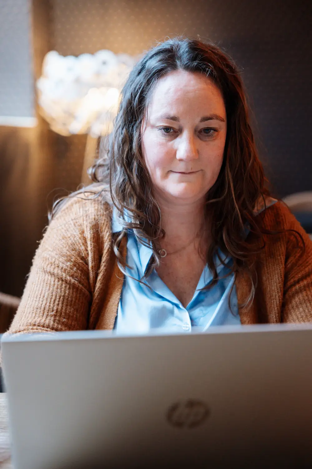 Annelies Neven werkt geconcentreerd achter haar laptop tijdens een online sessie