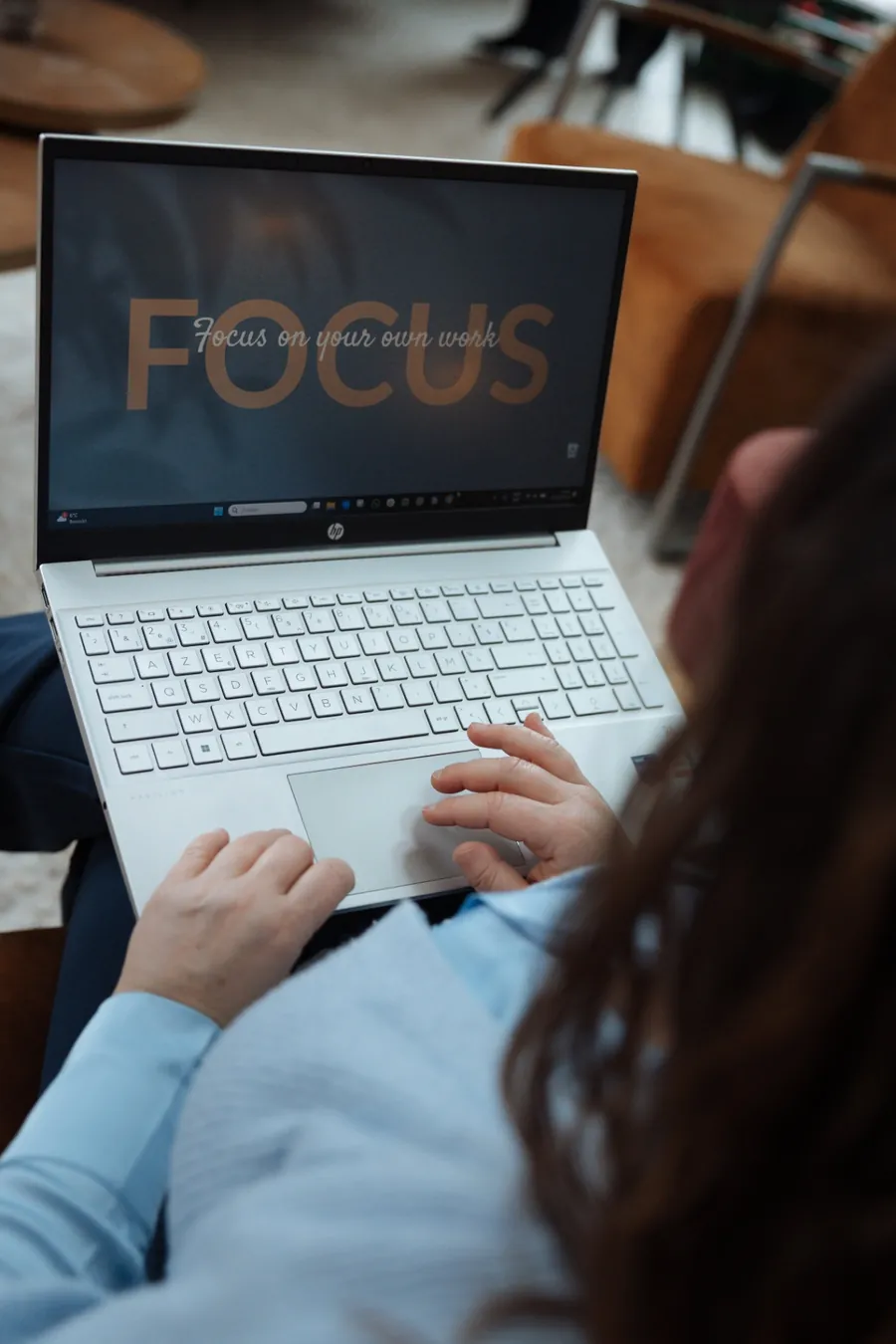 Laptop op schoot met de tekst FOCUS on your own work op het scherm